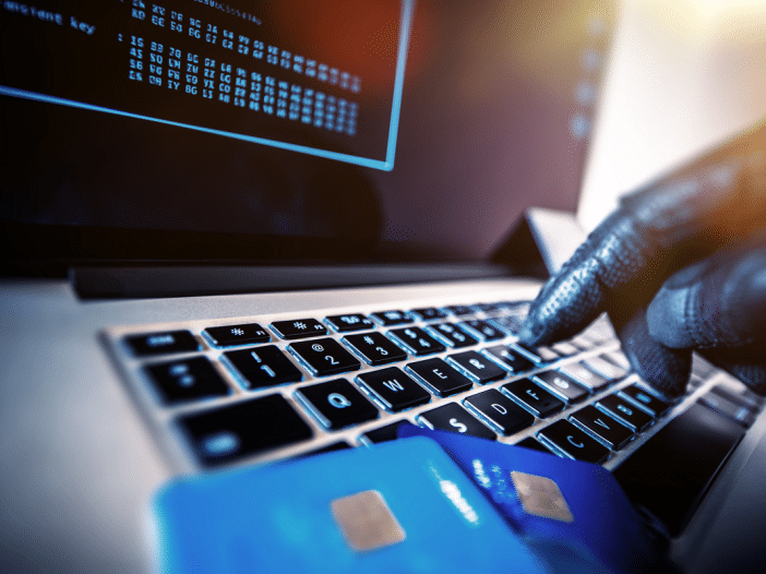 Hacker using stolen credit cards on a computer ransomware financial theft concept