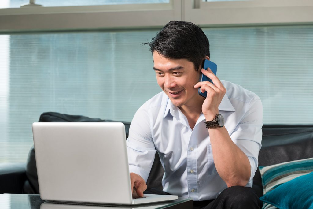 Businessman working with IT services customers on the phone to fix an issue